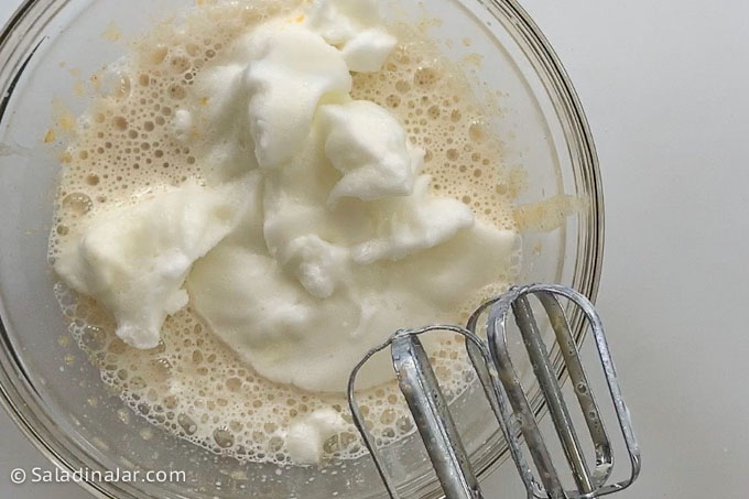 adding whipped egg whites to pumpkin mixture to make layers