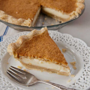 a slice of pumpkin custard pie on a plate with a fork.