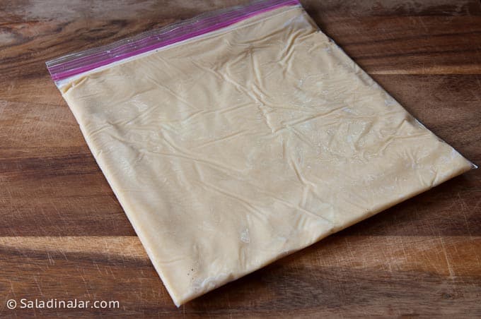 Frozen dough pressed flat into a ziplock bag