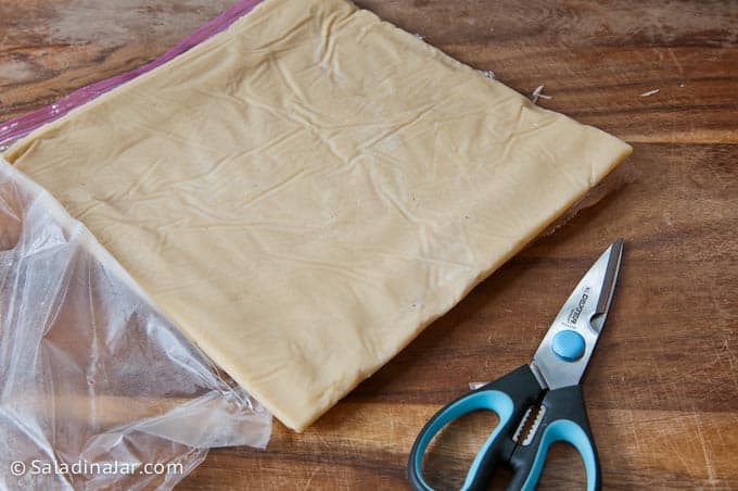 peeling the plastic back from the dough