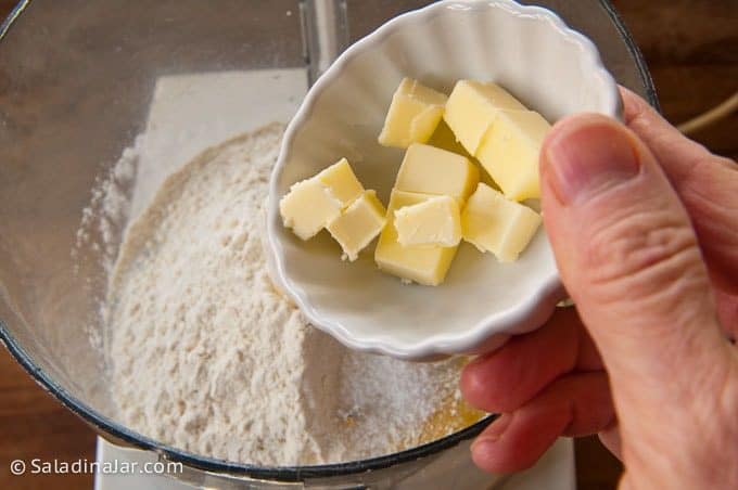 adding butter and eggs to flour
