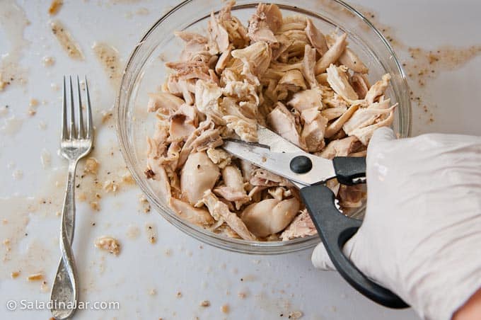 cutting chicken with kitchen scissors