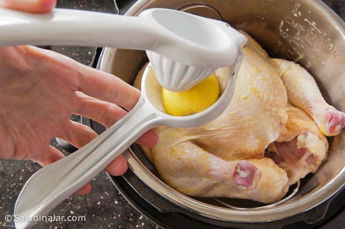 Squeezing a lemon over the chicken.