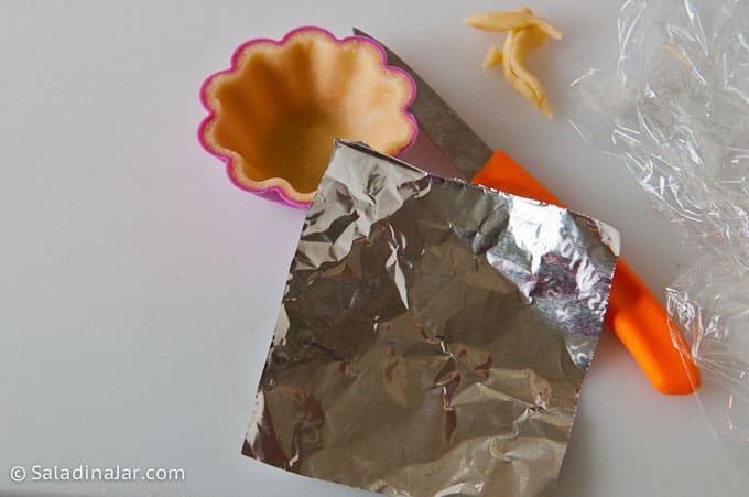 Using non-stick foil to keep crusts from puffing while in the oven