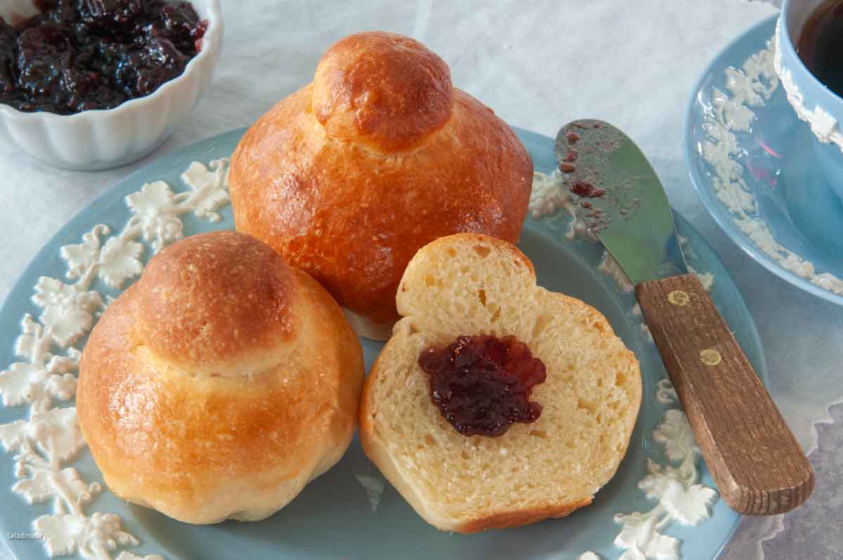 traditional Brioche rolls with jelly on the side and a cup of coffee.