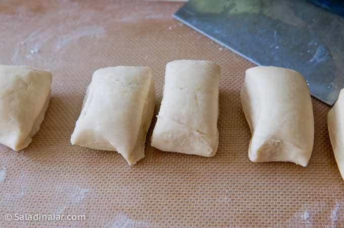 portioning brioche dough with a bench scraper