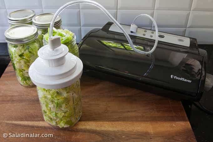 vacuum-packing a jar of lettuce with a counter-top full-size device