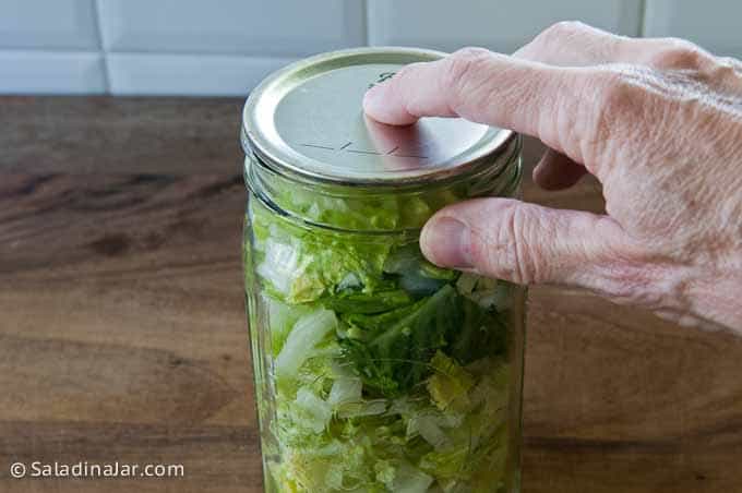 placing a flat metal lid on Mason jar underneath the Food Saver adapter.