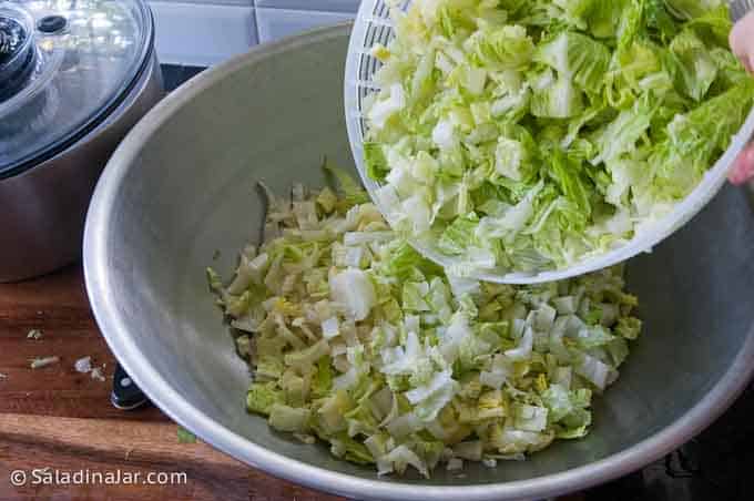 dumping spin-dry lettuce into a large bowl