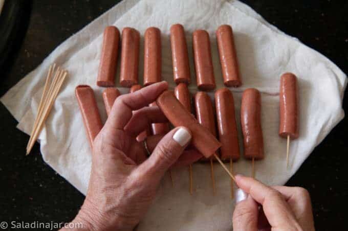 removing moisture from hot dogs and inserting sticks