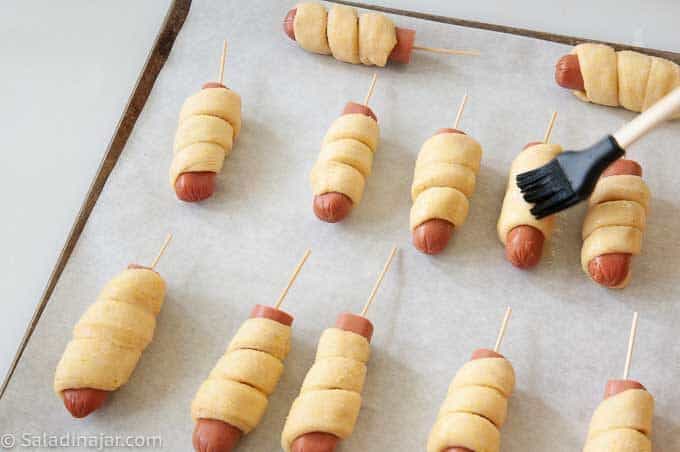 brushing corndogs with egg glaze