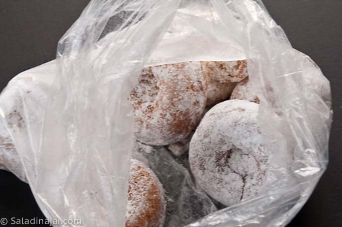 coating baked donuts with powdered sugar
