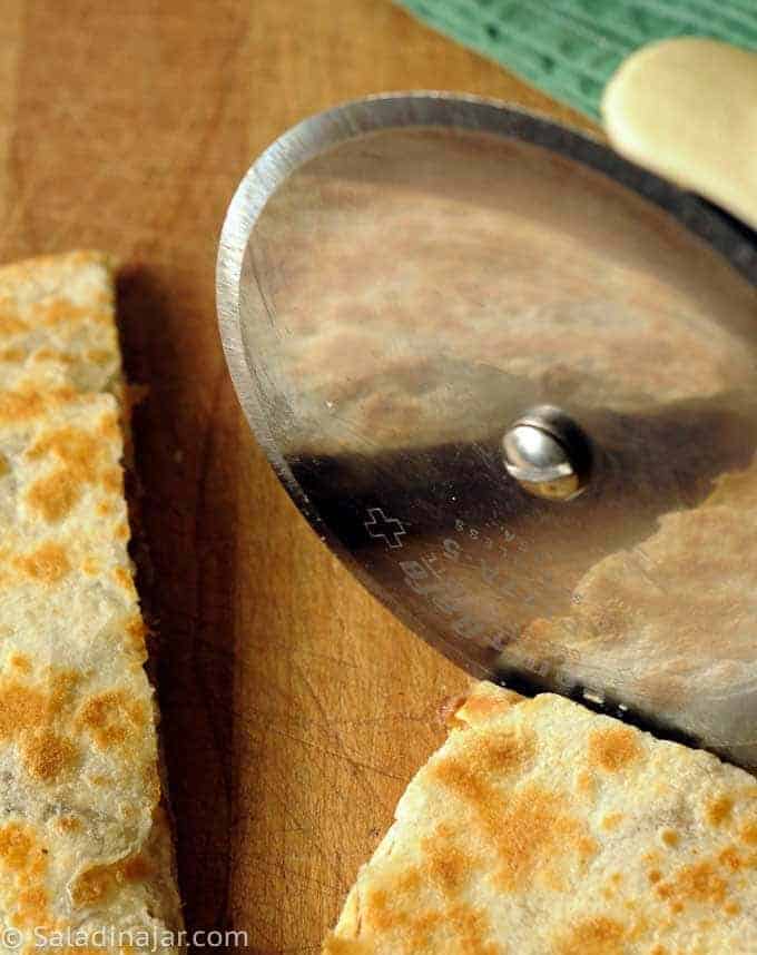 using a pizza cutter to portion quesadillas