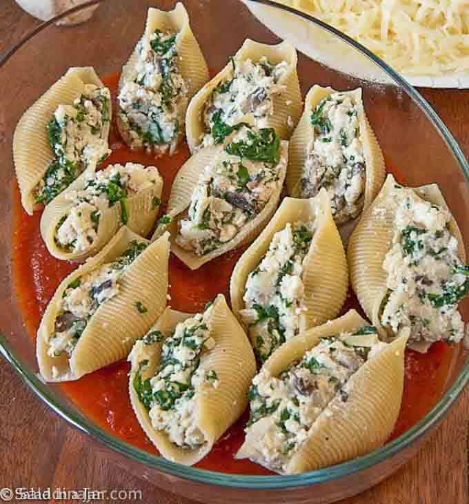 Cooked shells stuffed with cheese are almost ready to bake.