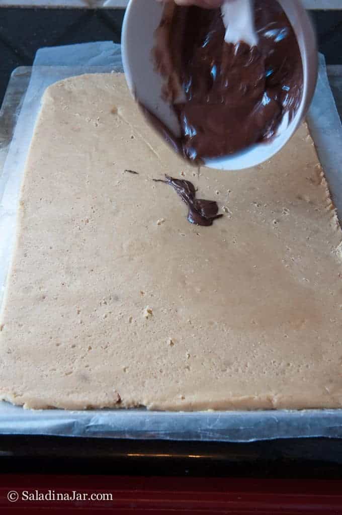 pouring chocolate layer on cookie dough
