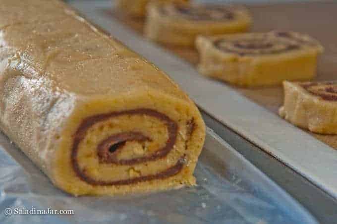 sliced cookies going onto a cookie sheet