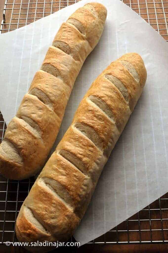 two uncut loaves of French Bread on a cooling rack