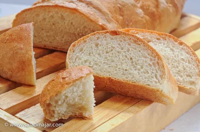 Crusty French Bread sliced on a crumb catcher box.