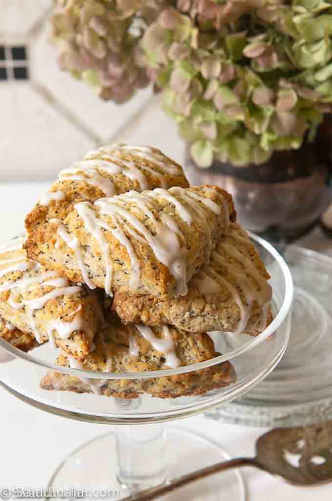 LEMON POPPY-SEED SCONES WITH GREEK YOGURT in a serving dish with flowers behind it