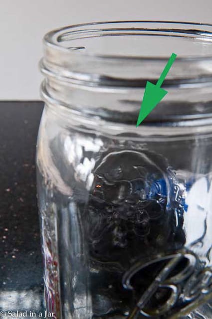 arrow points to irregularity in the Mason jar.