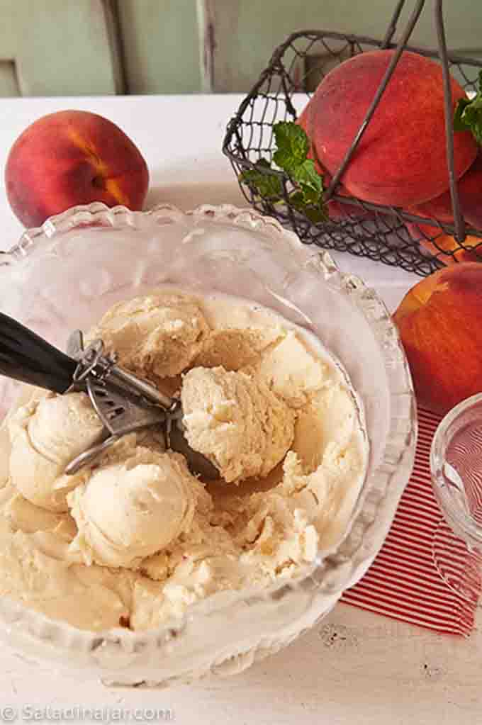 Peach Frozen Yogurt in a bowl with ice cream scoop