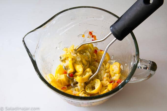 mashing cooked and drained veggies