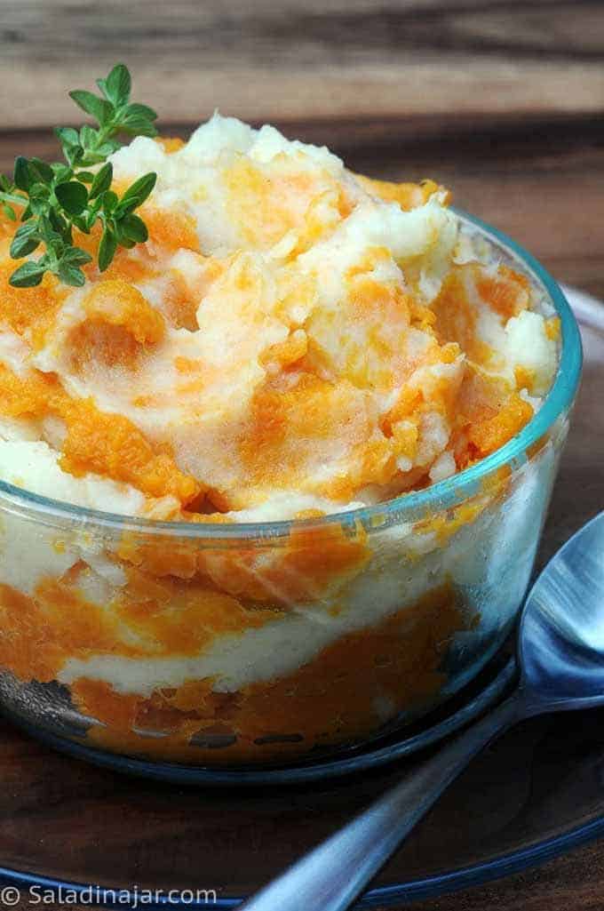 Mashed Sweet and White Potatoes in a dish garnished with thyme