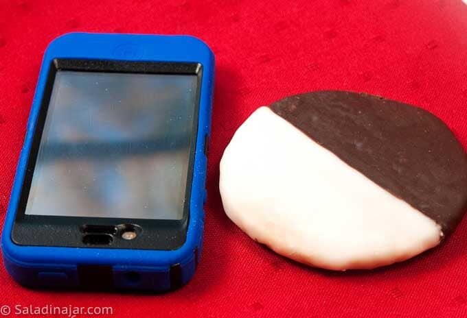 comparing a mini black and white cookie to an iphone in size