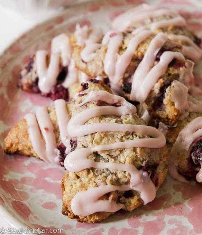 FROSTED FRESH BLACKBERRY SCONES on a pink plate ready to eat.