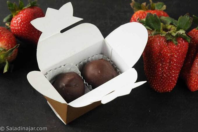 truffles in a gift box next to strawberries