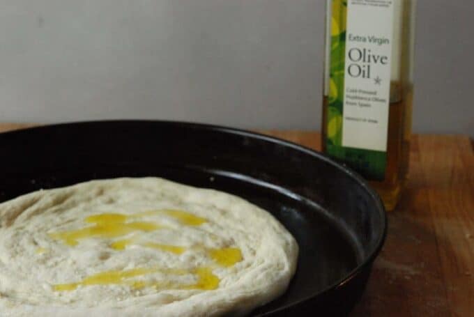 dough in pan with olive oil on top