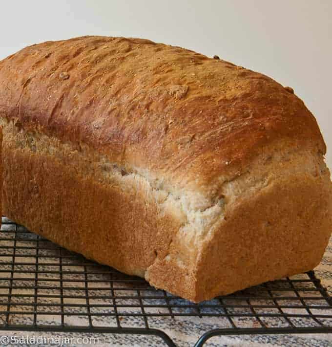 loaf of bread mixed in a bead machine and baked in the oven sitting on a cooling rack.