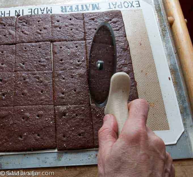 recutting chocolate graham crackers with a pizza wheel.