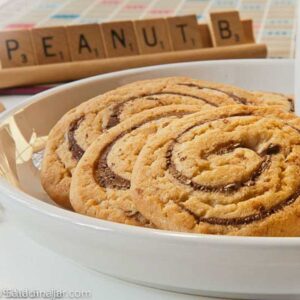Peanut Butter Pinwheel Cookies on a dish in from of a Scrabble tray of letters.