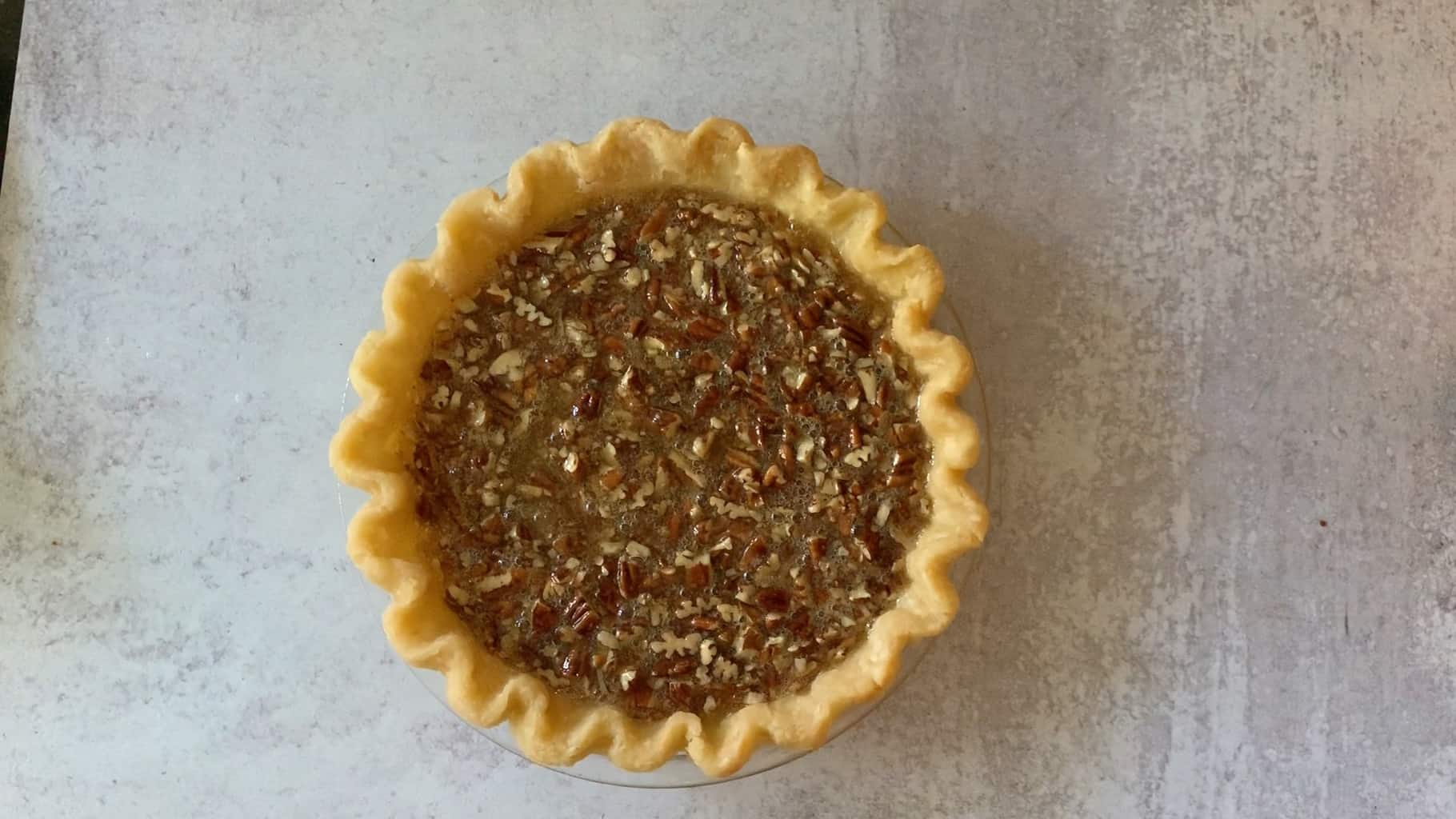 unbaked pecan pie ready to go in the oven