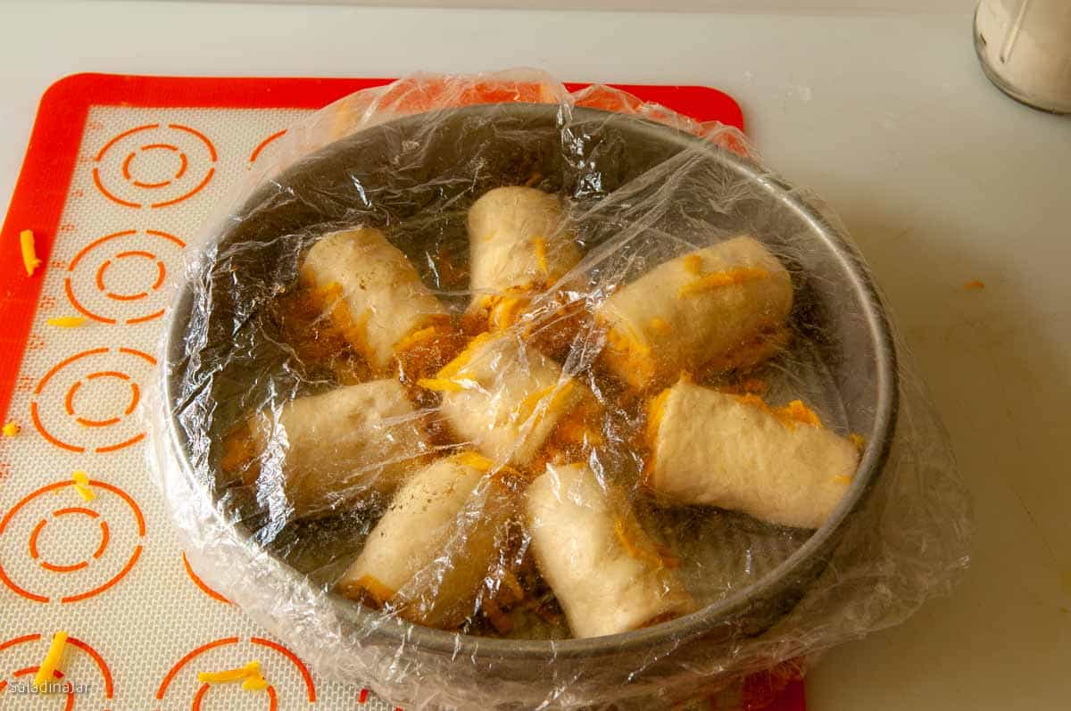 Rolls arrange in a circular pan and covered with a cheap shower cap.