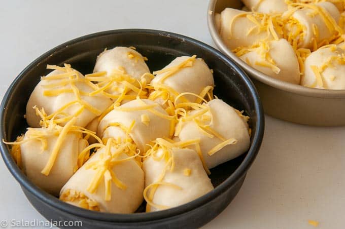 raw cheese bread rolls (doubled in size) ready to bake