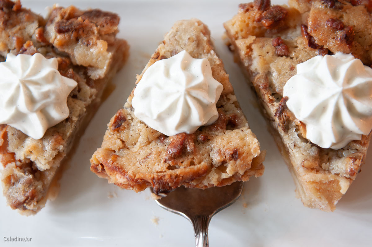 slices of baked apple pie with whipped cream garnish.