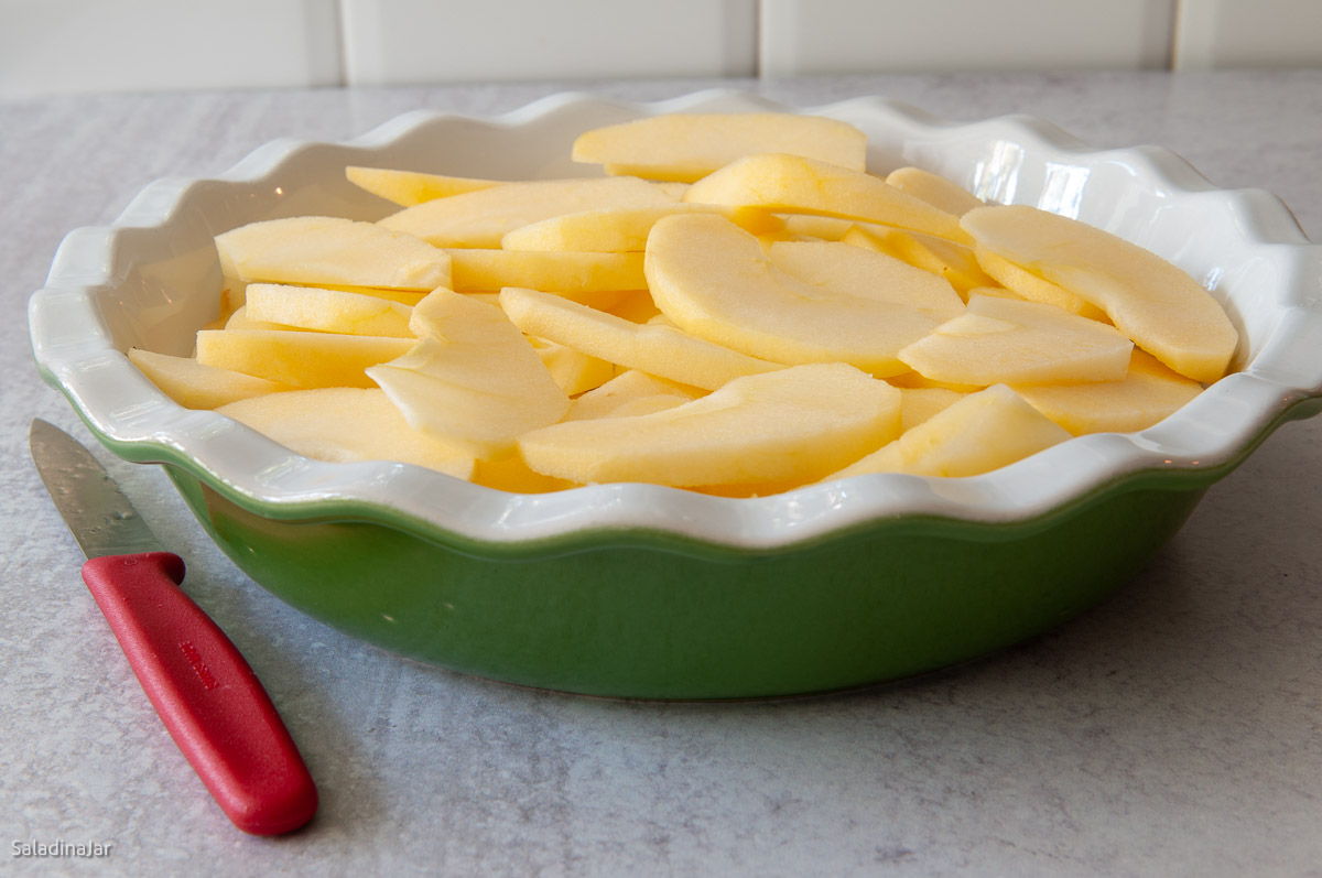 sliced apples in pie plate.