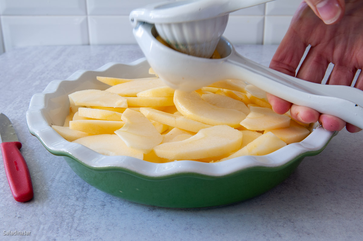 squeezing lemon juice over apples.