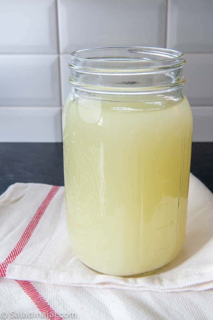 Greek yogurt leaking whey from a quart jar 