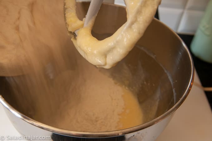 pouring drying ingredients into the creamed mixture