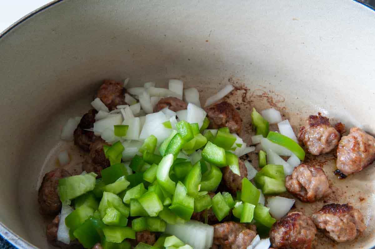 adding onions and green peppers to pot.