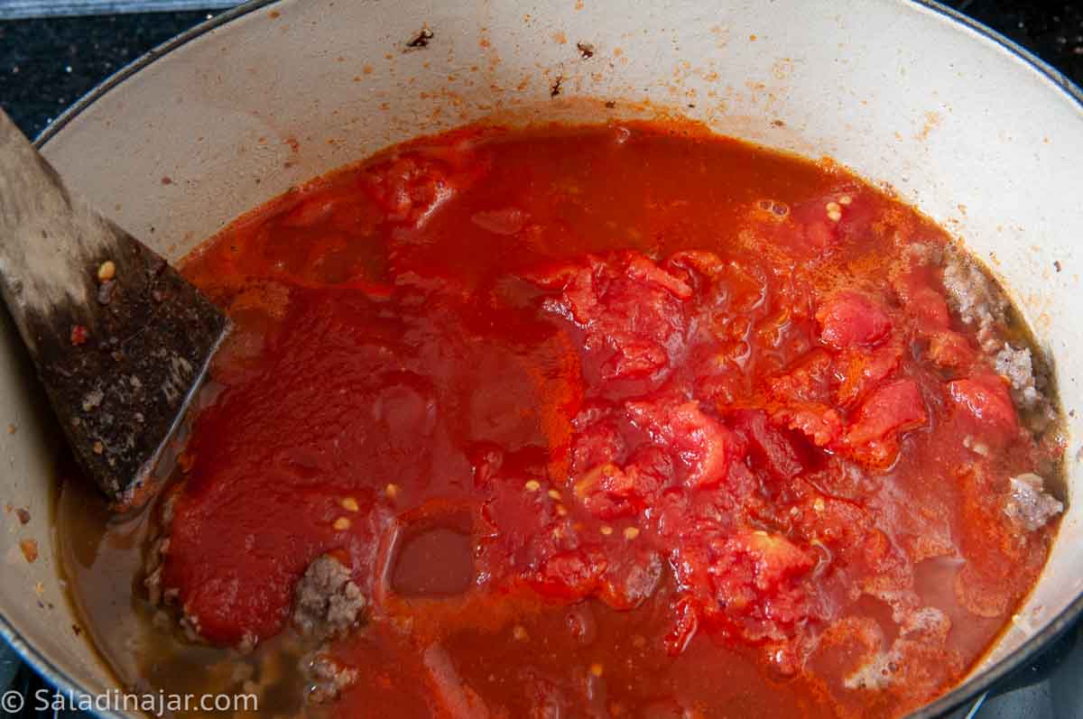 Adding tomato sauce, tomatoes and remaining water