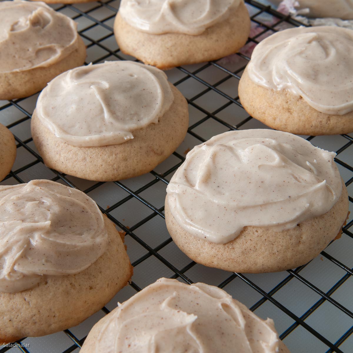 soft cinnmon cookies with brown butter iicing on a cooling rack.