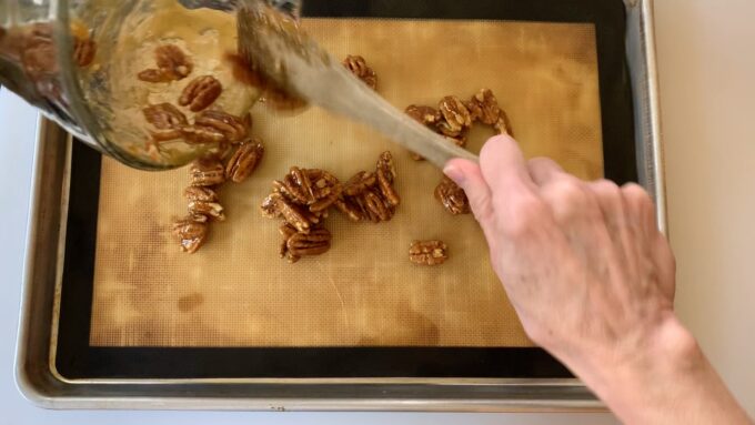 spreading pecans onto a cookie sheet