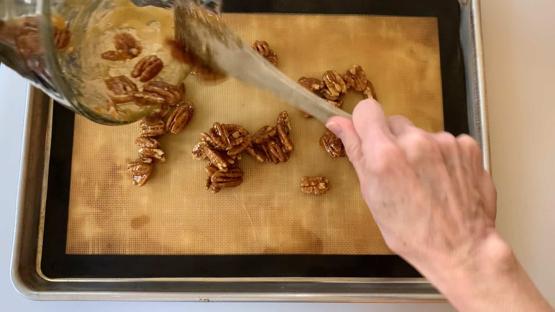 spreading pecans onto a cookie sheet