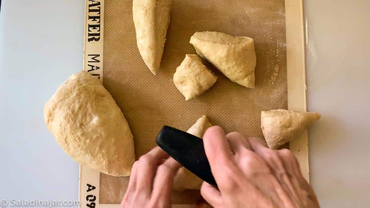 Portioning the dough for rolls with a bench scraper