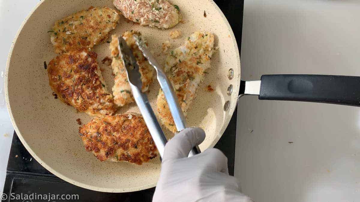 turning chicken filets in skillet