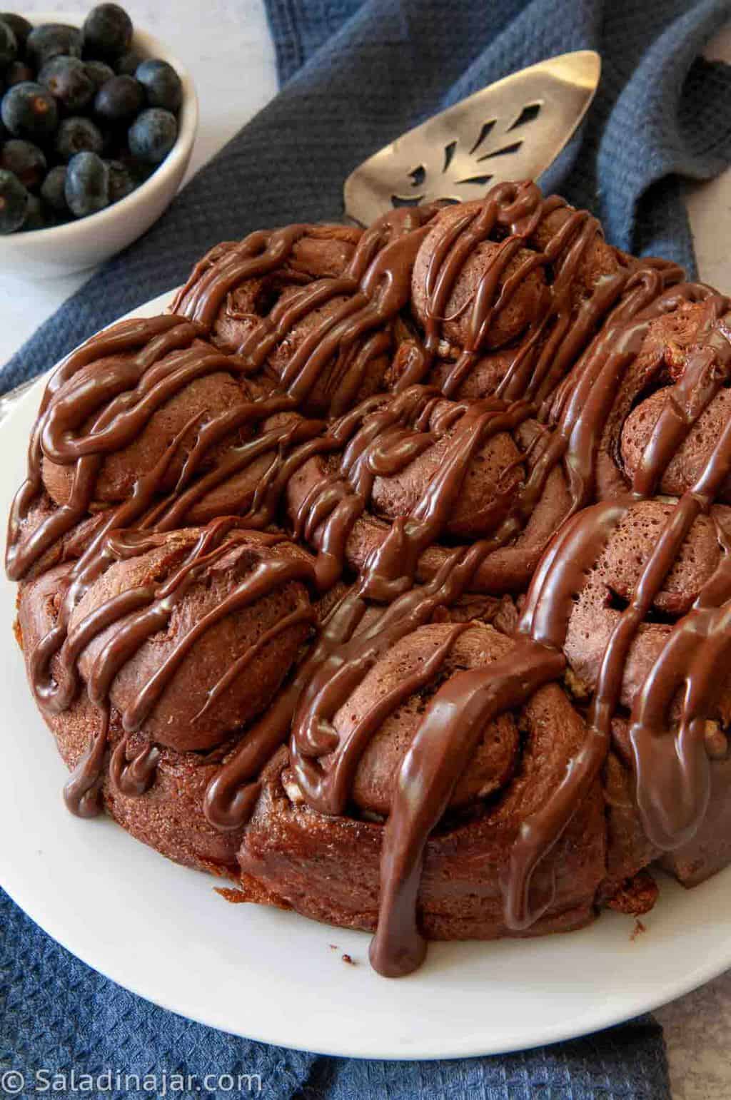 Ready-to-eat Chocolate Cinnamon Rolls with Chocolate Frosting drizzled over the top.
